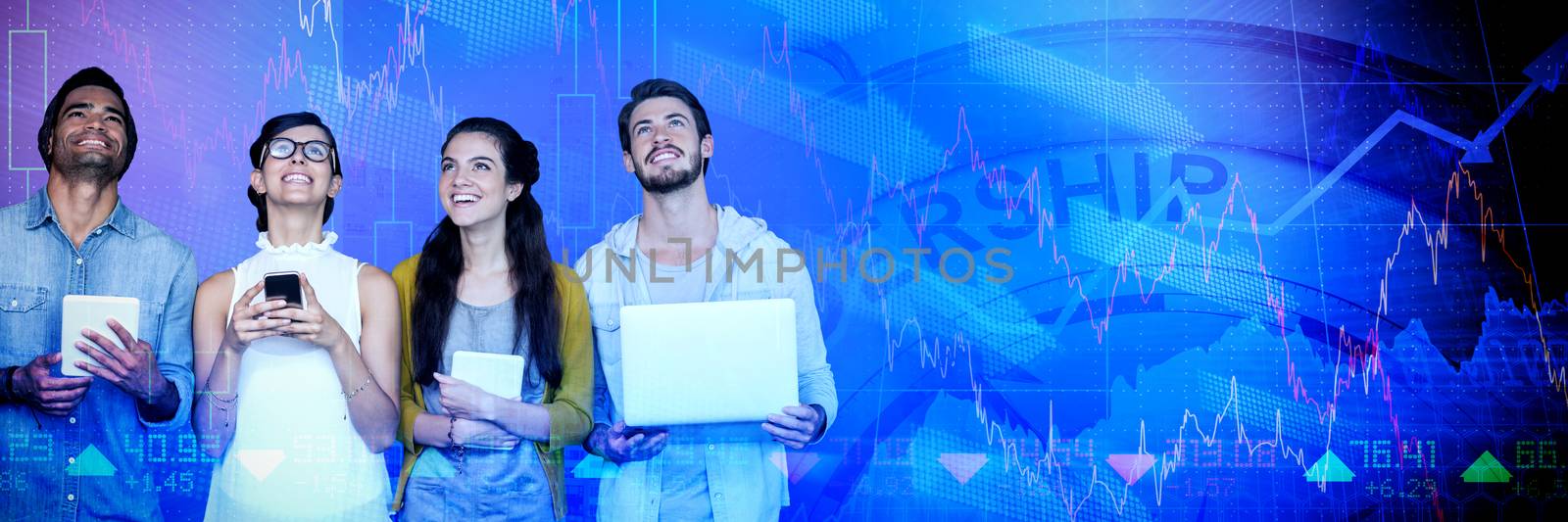 Smiling business people holding technology while looking up against high angle view of crowded buildings in city