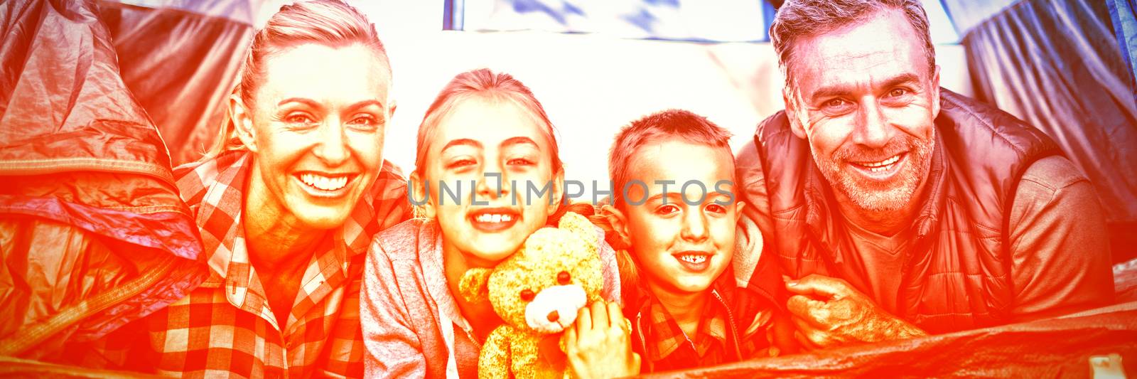 Portrait of smiling family lying in the tent