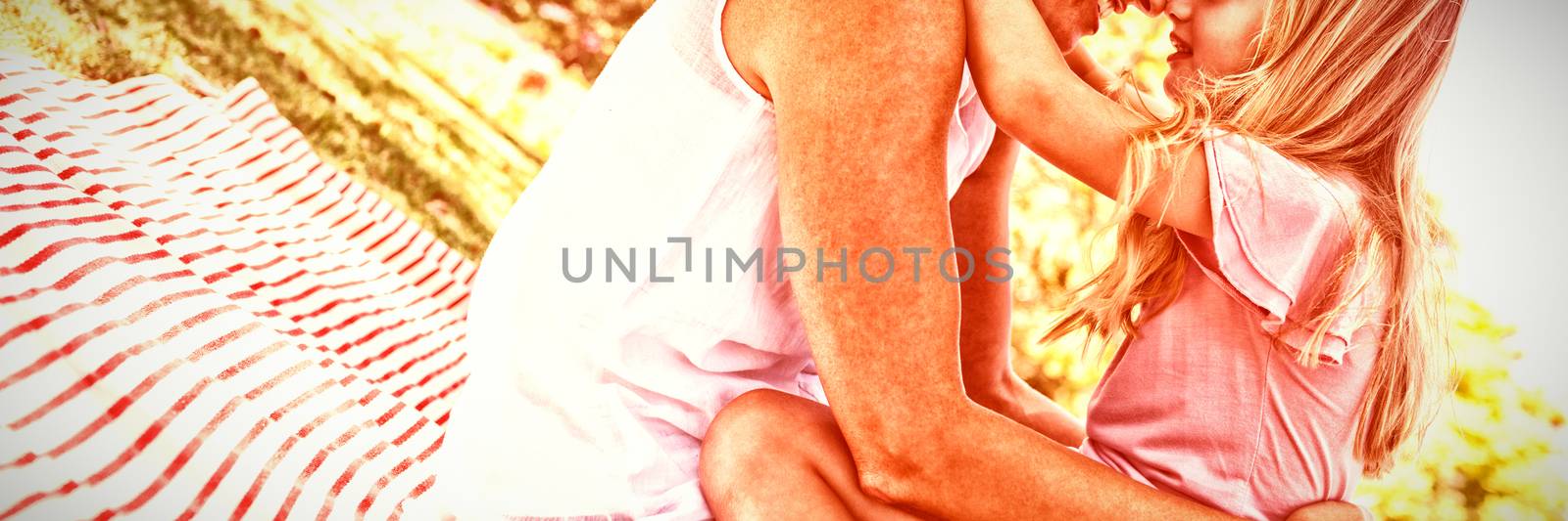 Happy mother embracing her daughter in park on a sunny day