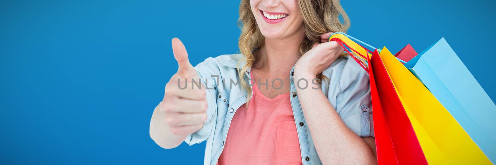 Woman holding some shopping bags against abstract blue background