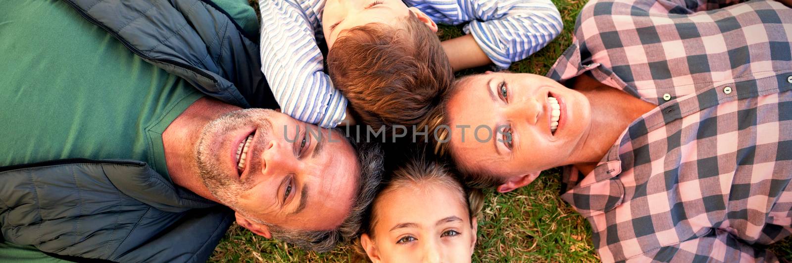 Happy family lying on the grass by Wavebreakmedia