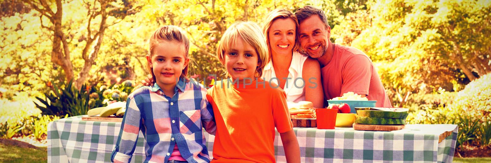 Portrait of happy family sitting at table in park