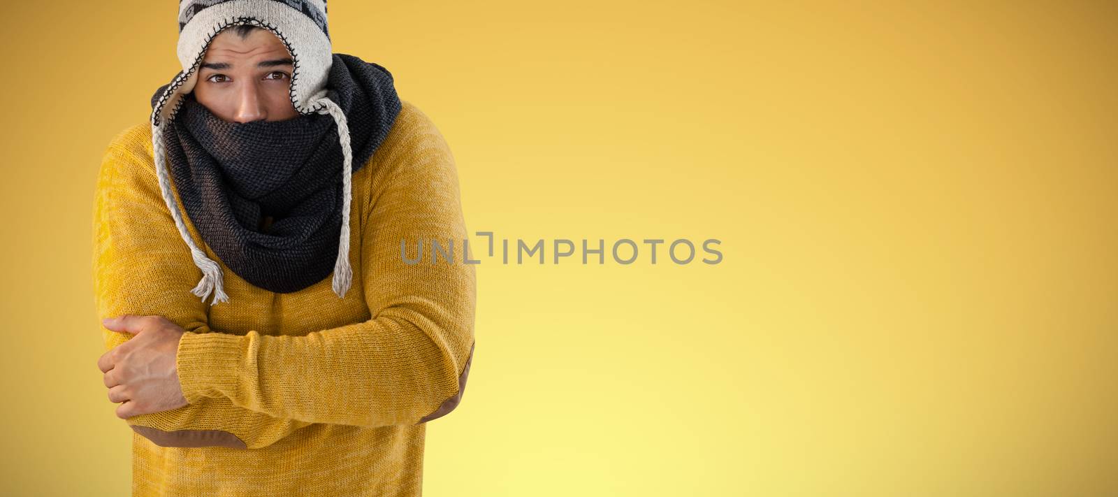 Portrait of man feeling cold against abstract yellow background