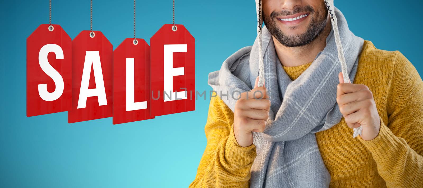 Portrait of smiling man holding wooly hat against abstract blue background