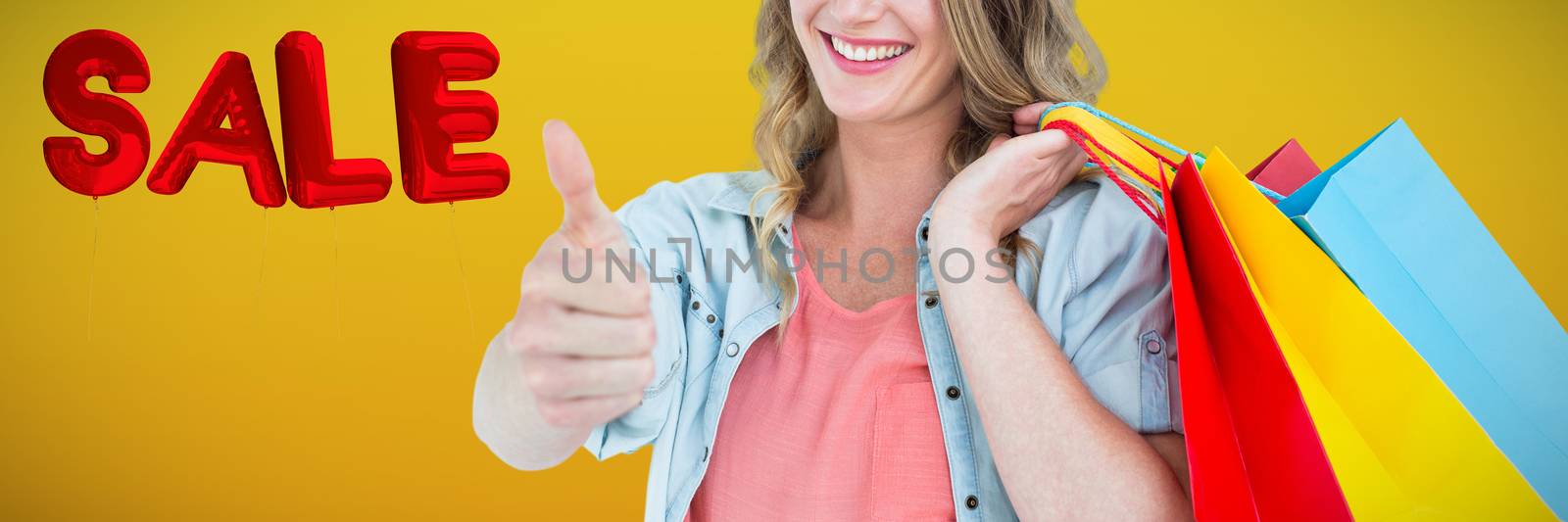 Woman holding some shopping bags against abstract mustard background