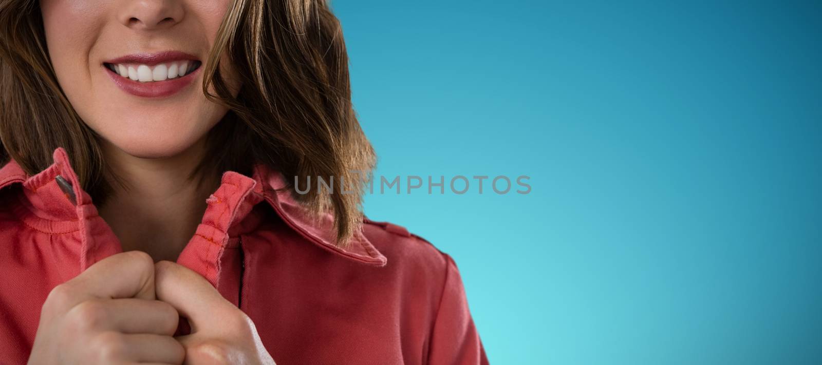 Close-up portrait of smiling young woman against abstract blue background