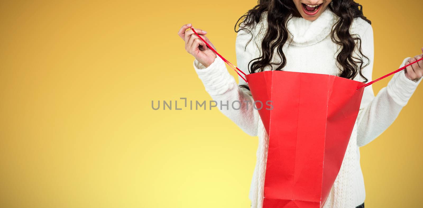 Composite image of surprised woman with christmas hat looking in red shopping bag by Wavebreakmedia