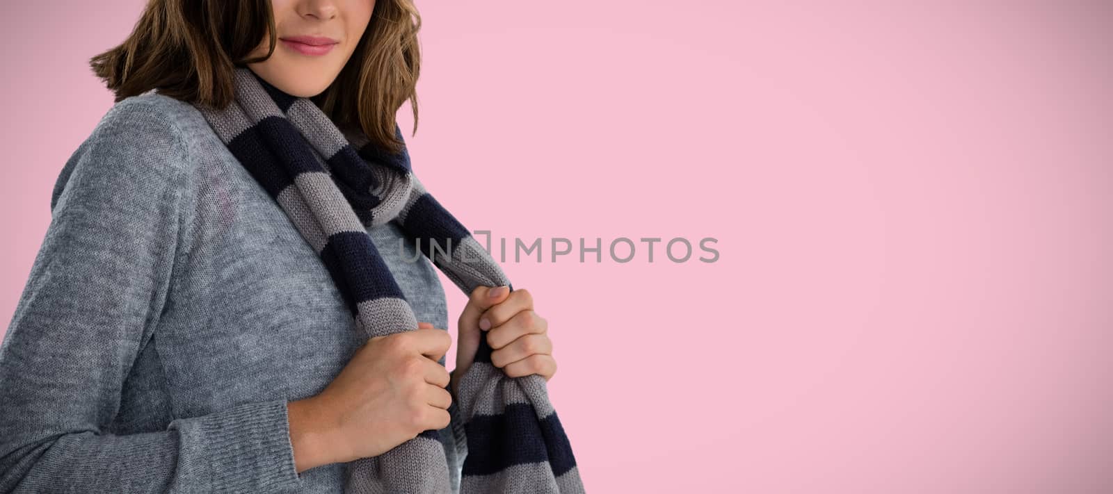 Portrait of young woman in scarf against pink background
