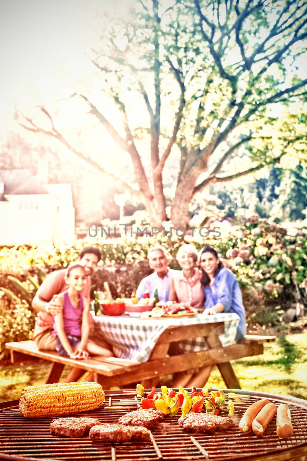 Close-up of barbecue and family sitting on the table by Wavebreakmedia