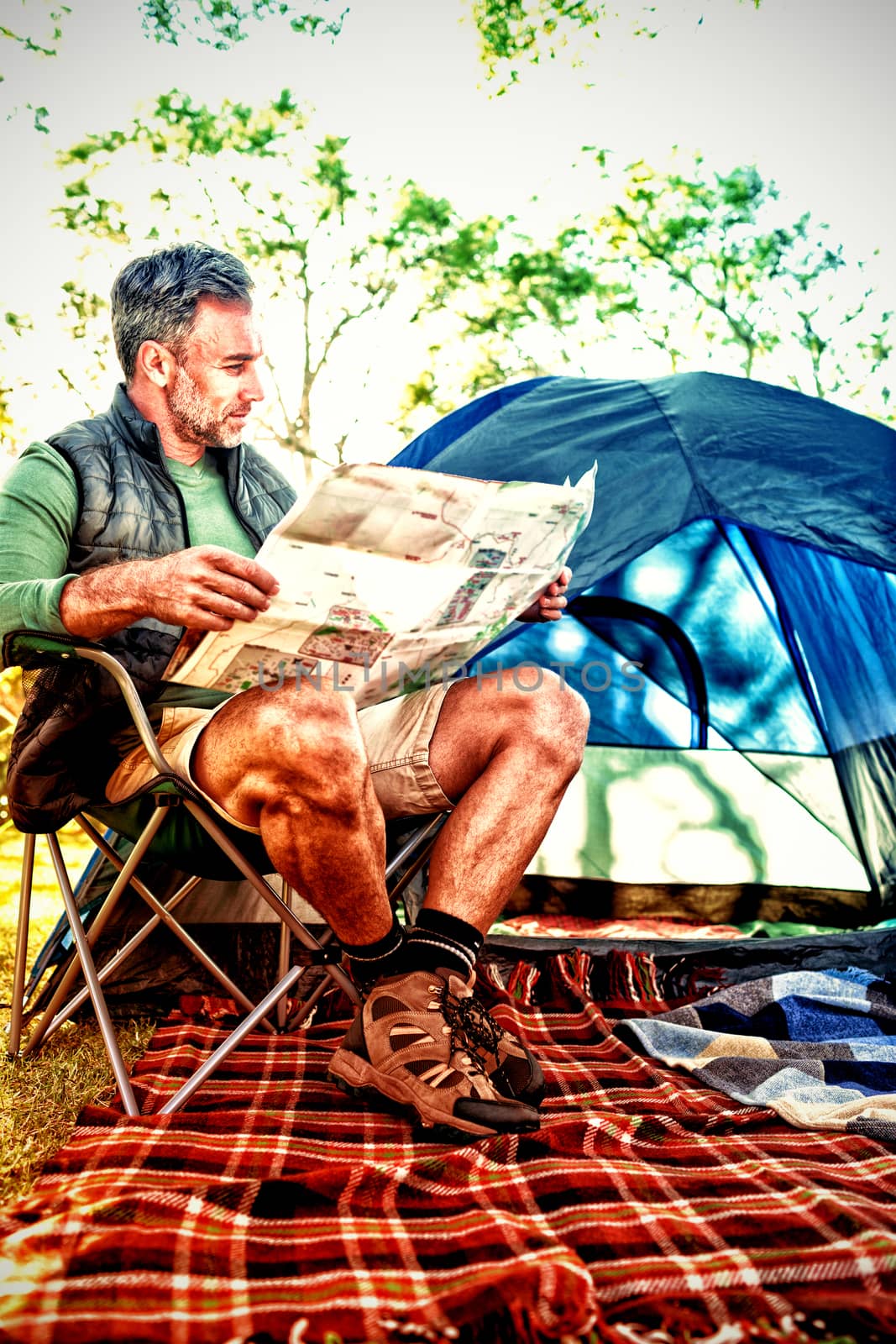 Man reading the map outside the tent at campsite