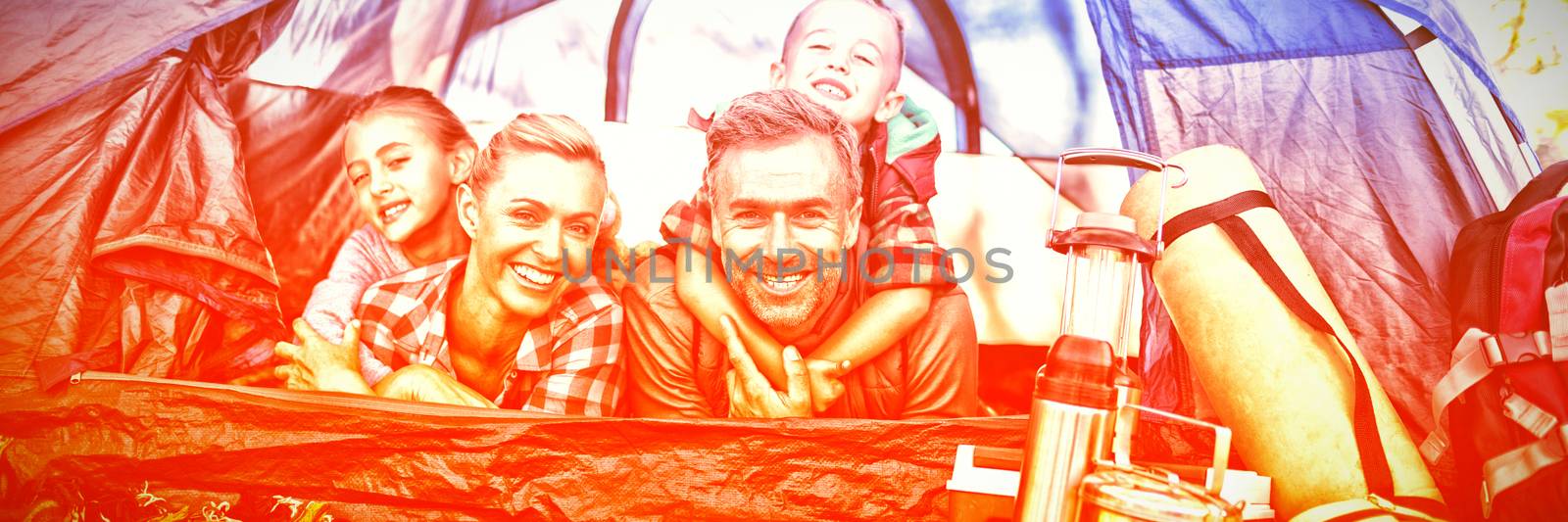 Smiling family lying in the tent by Wavebreakmedia