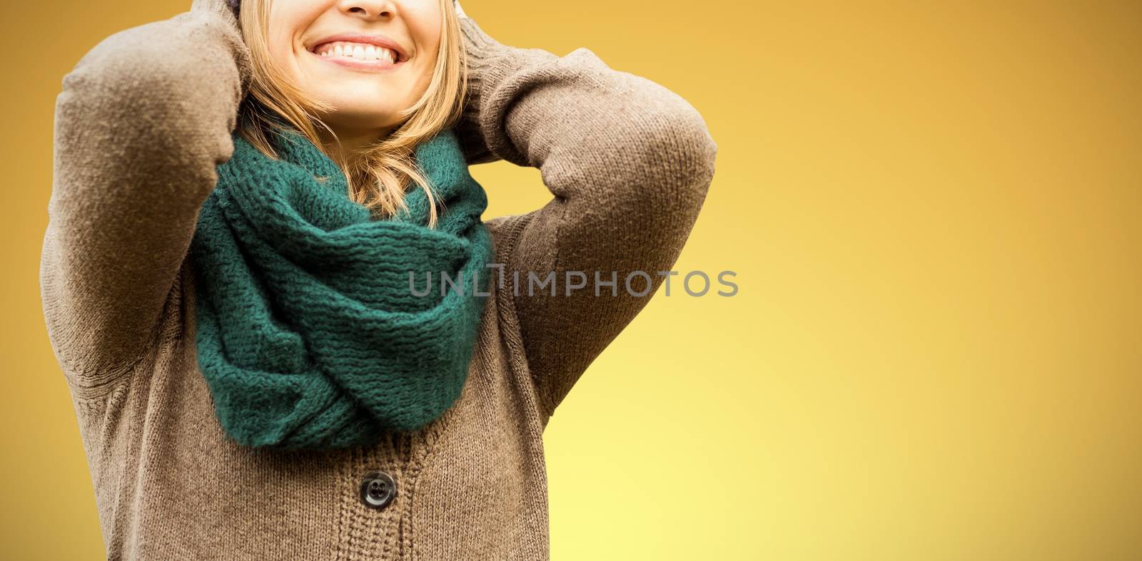  Beautiful blond woman with cap and scarf smiling against abstract yellow background