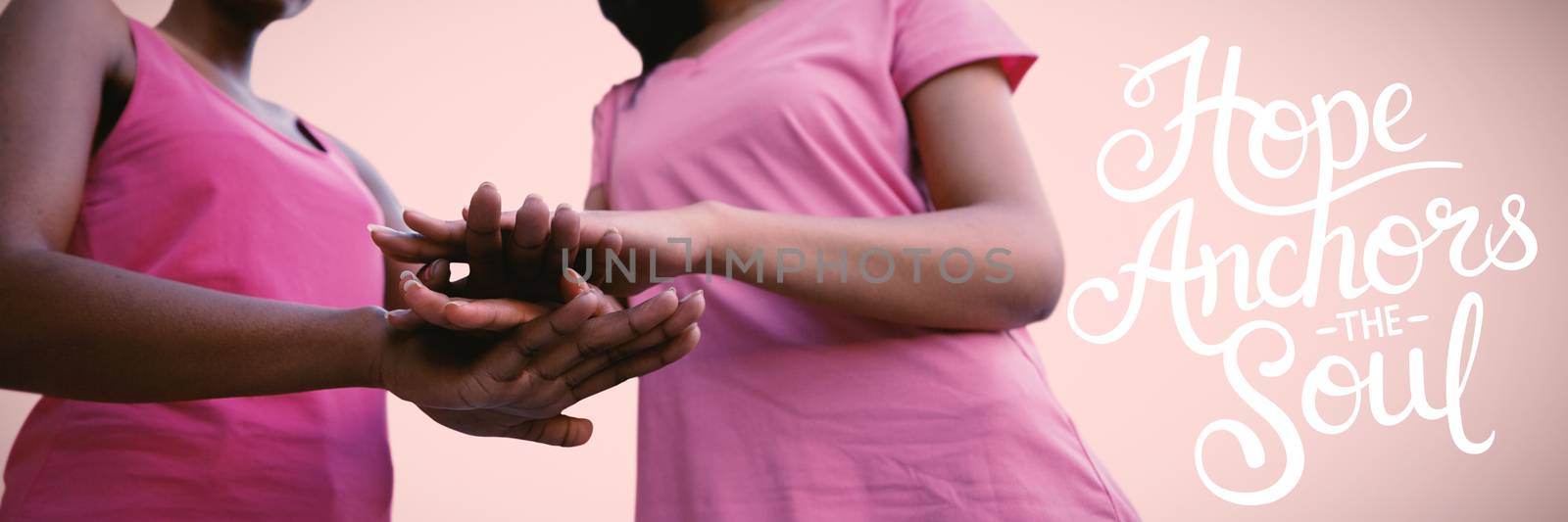 two black women joining hands against pink background 