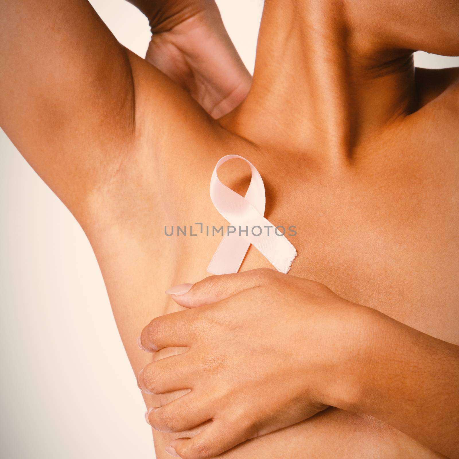 Shirtless woman for breast cancer awareness with ribbon on white background