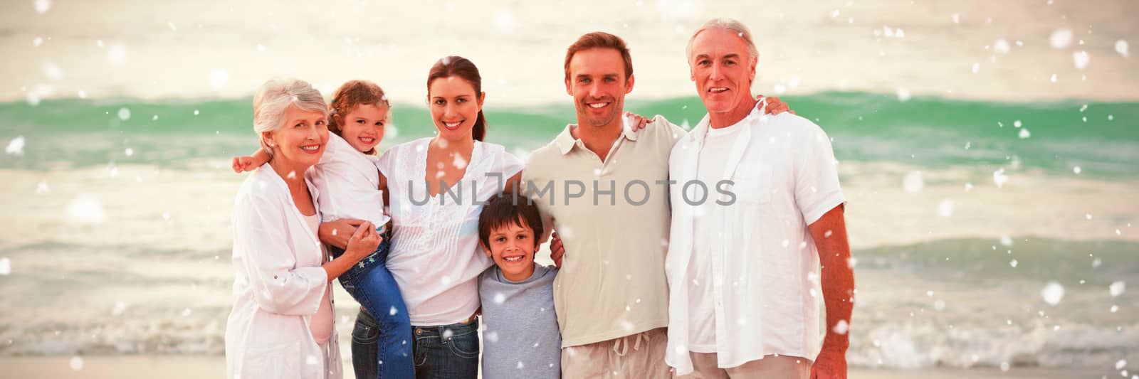 Beautiful family at the beach against snow falling