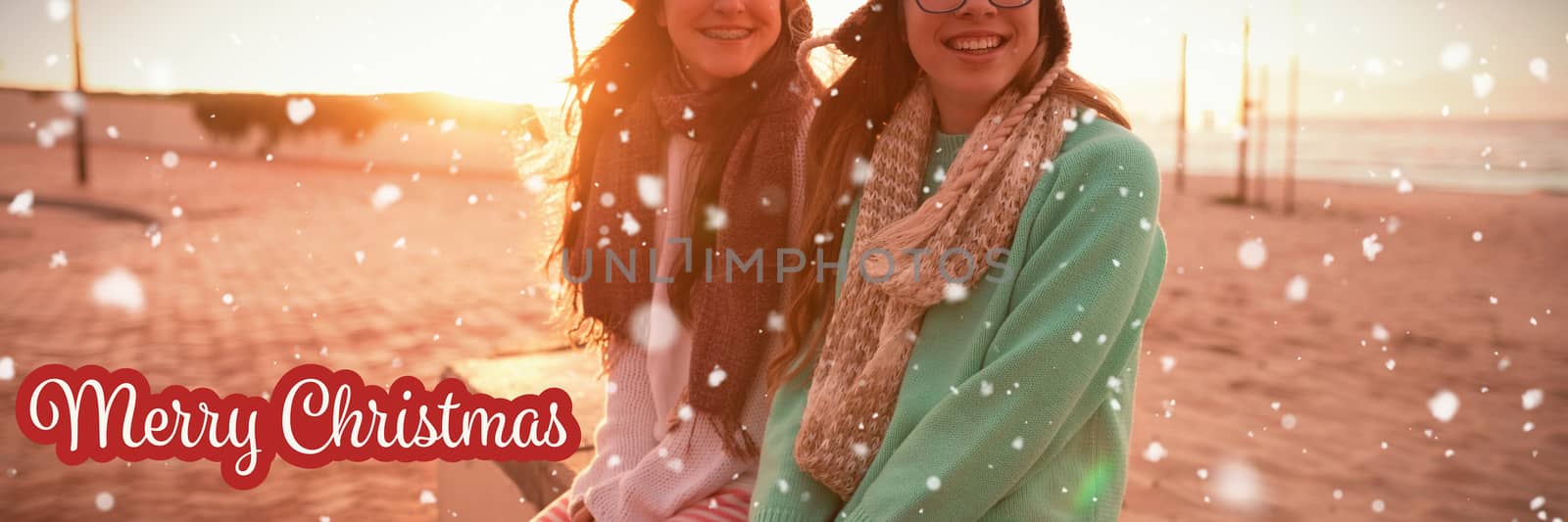 White and red greeting card against  female friends sitting together on bench at beach Female friends sitting together on bench at beach during sunset