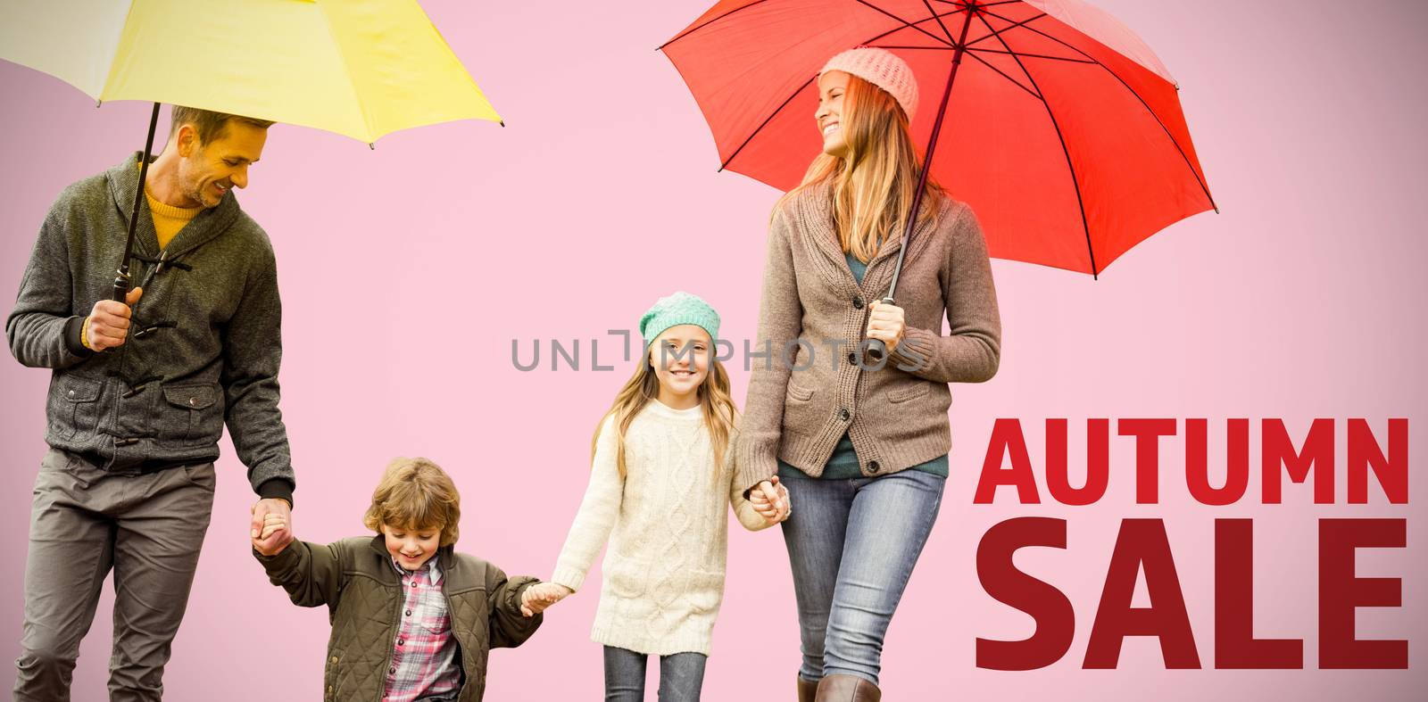  Smiling young family under umbrella against pink background 