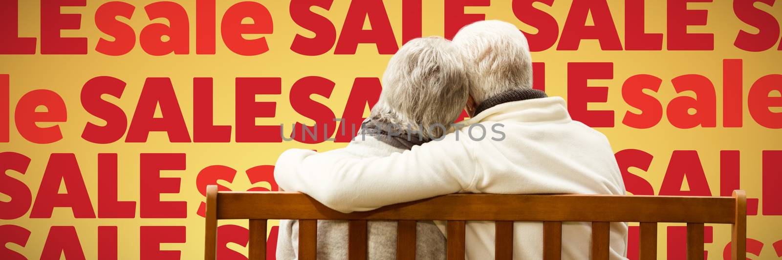  Senior couple embracing on a bench against abstract yellow background