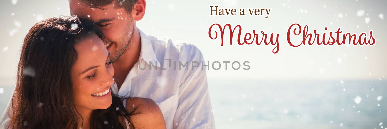 Attractive couple cuddling against christmas card