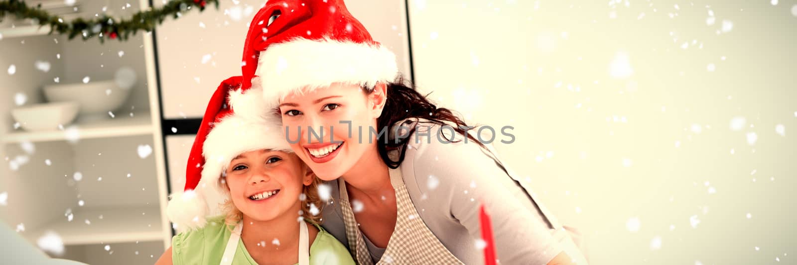 Portrait of a cute girl with her mother baking Christmas cookies against snow falling