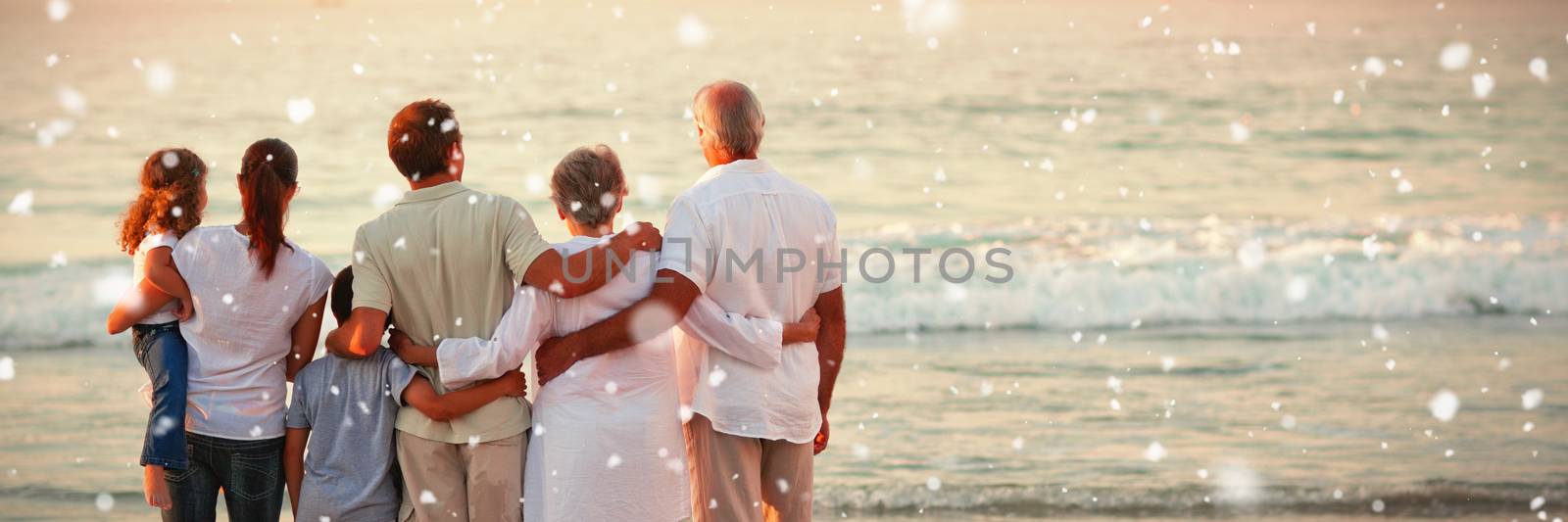 Beautiful family at the beach against snow falling