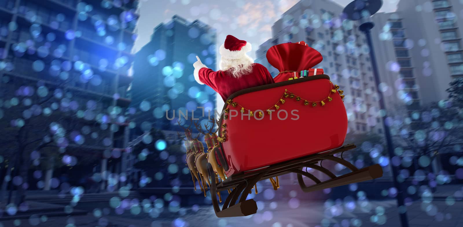 Santa Claus riding on sled with gift box against buildings against sky on sunny day