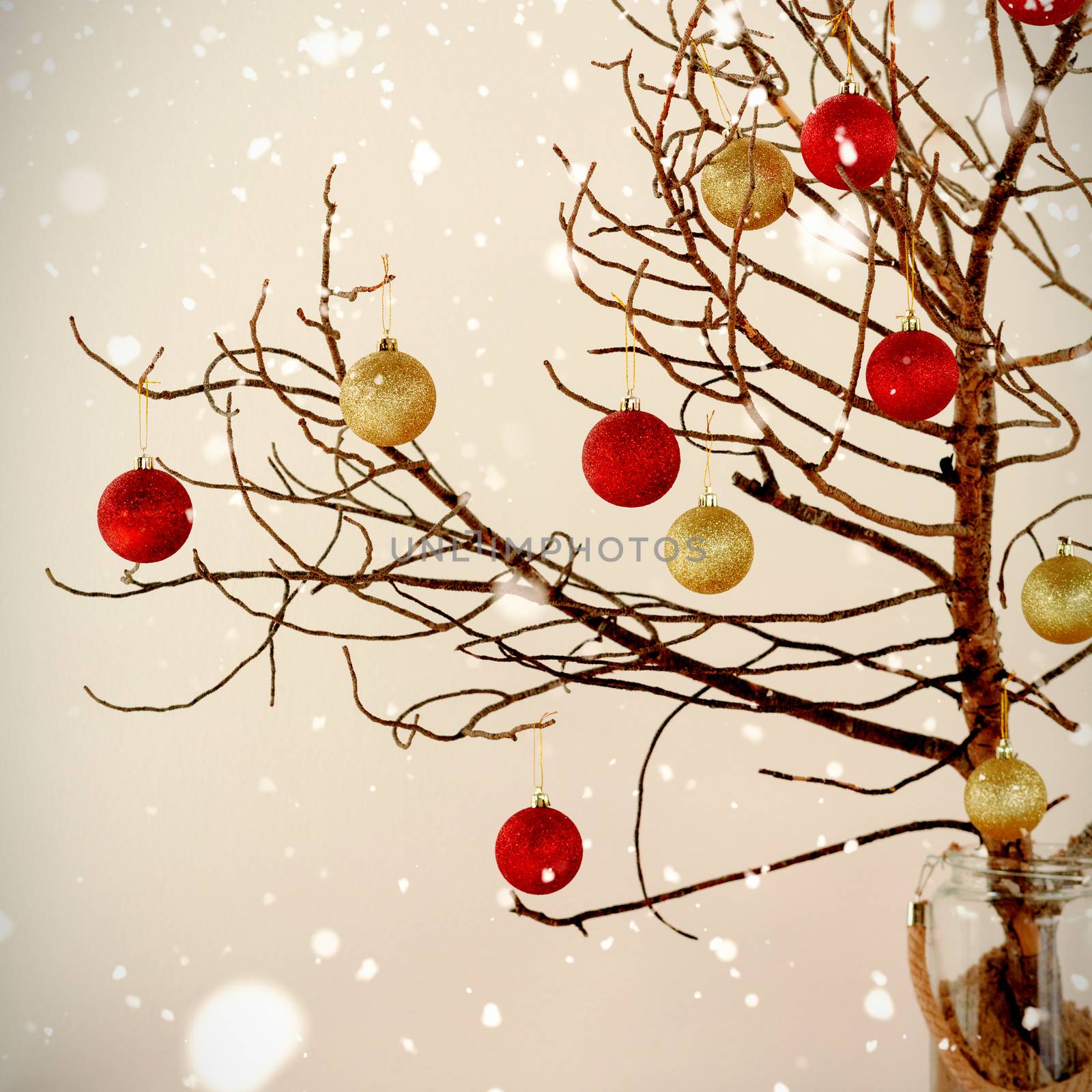 Snow falling against red and yellow christmas balls