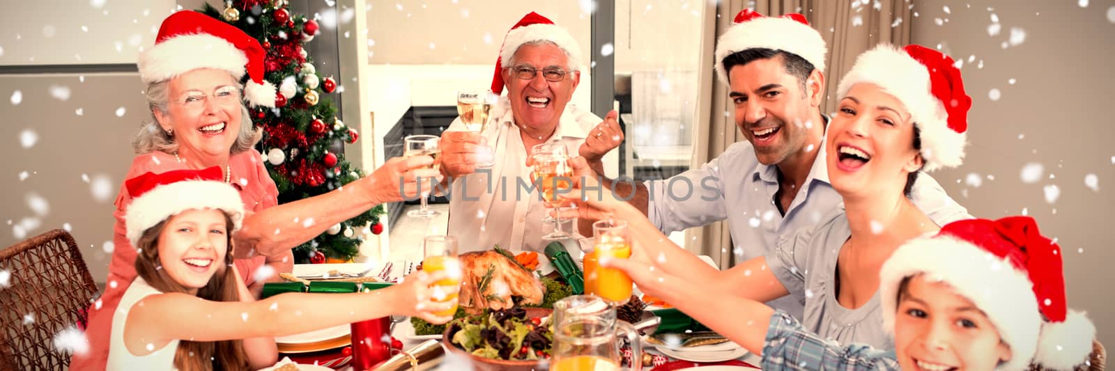 Family in santas hats toasting wine glasses at dining table against snow falling