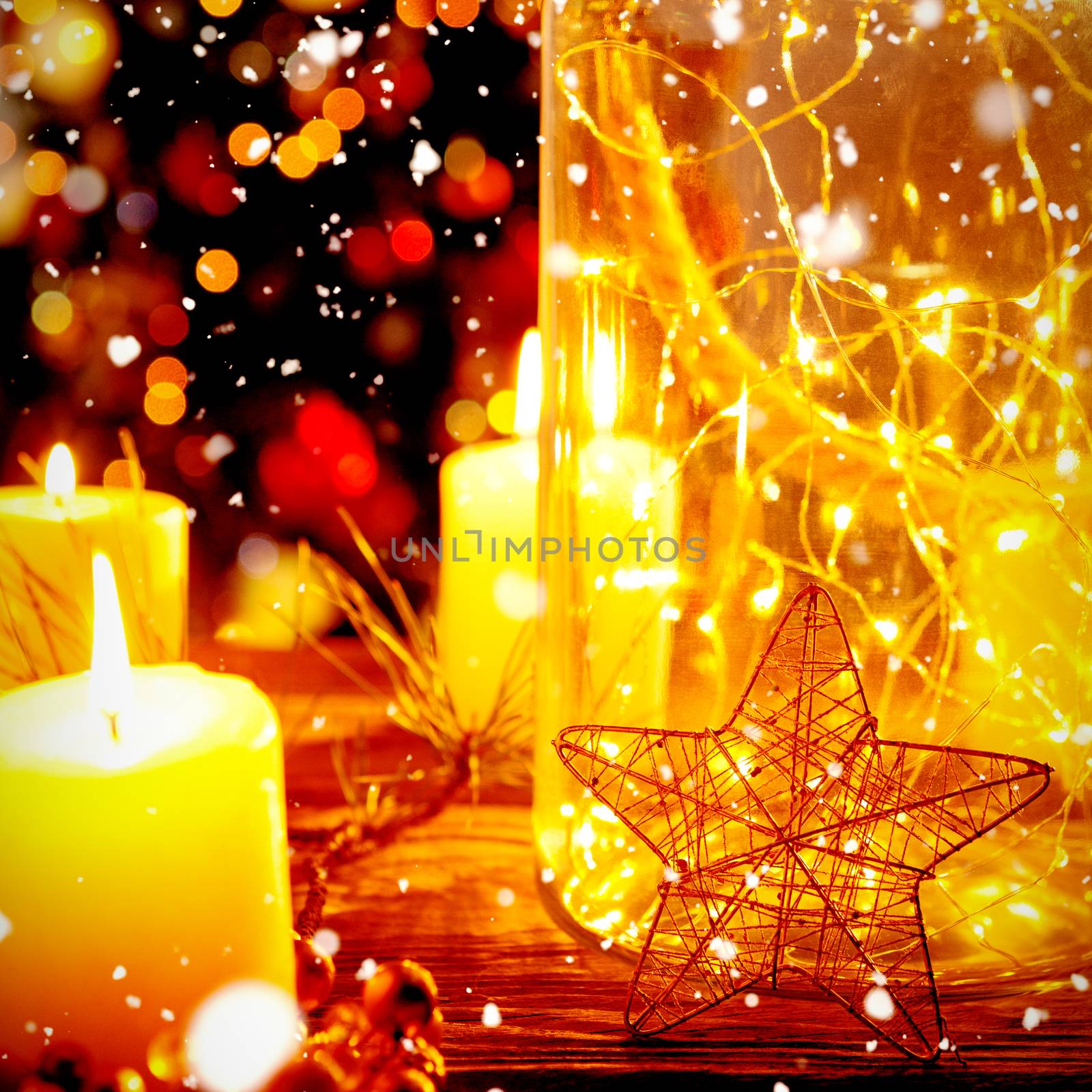 Snow falling against christmas electric garland in a glass jar with candles