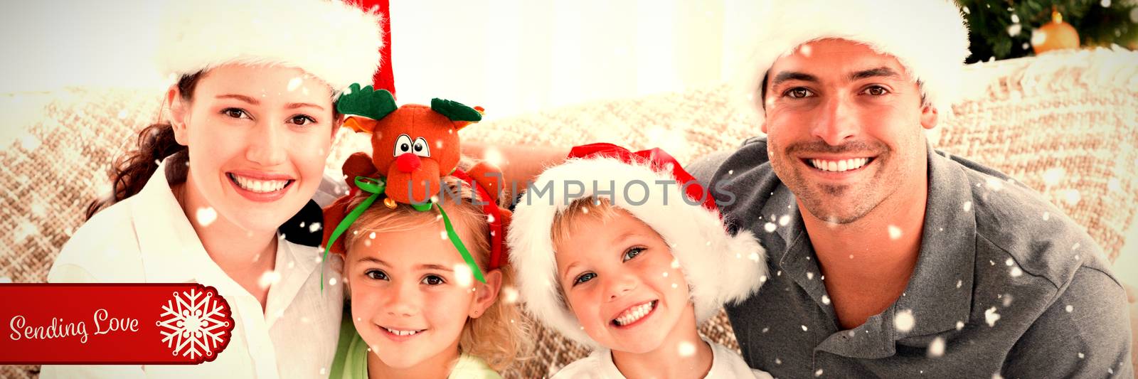 Composite image of portrait of a happy family with christmas hats sitting on the sofa by Wavebreakmedia