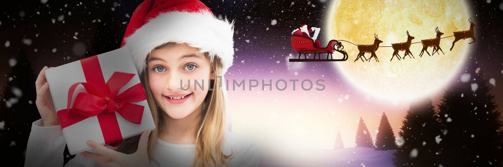 Portrait of smiling girl holding Christmas gift against white background against full moon over snowy landscape