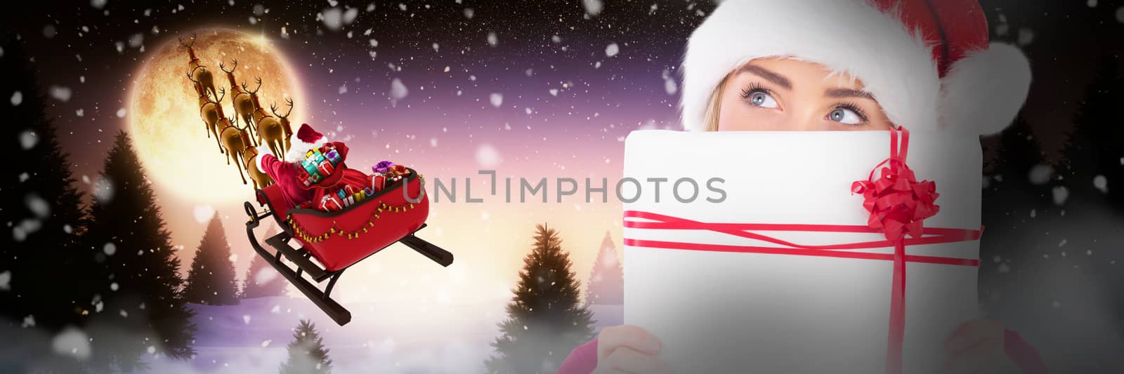 Composite image of festive blonde holding christmas gift by Wavebreakmedia
