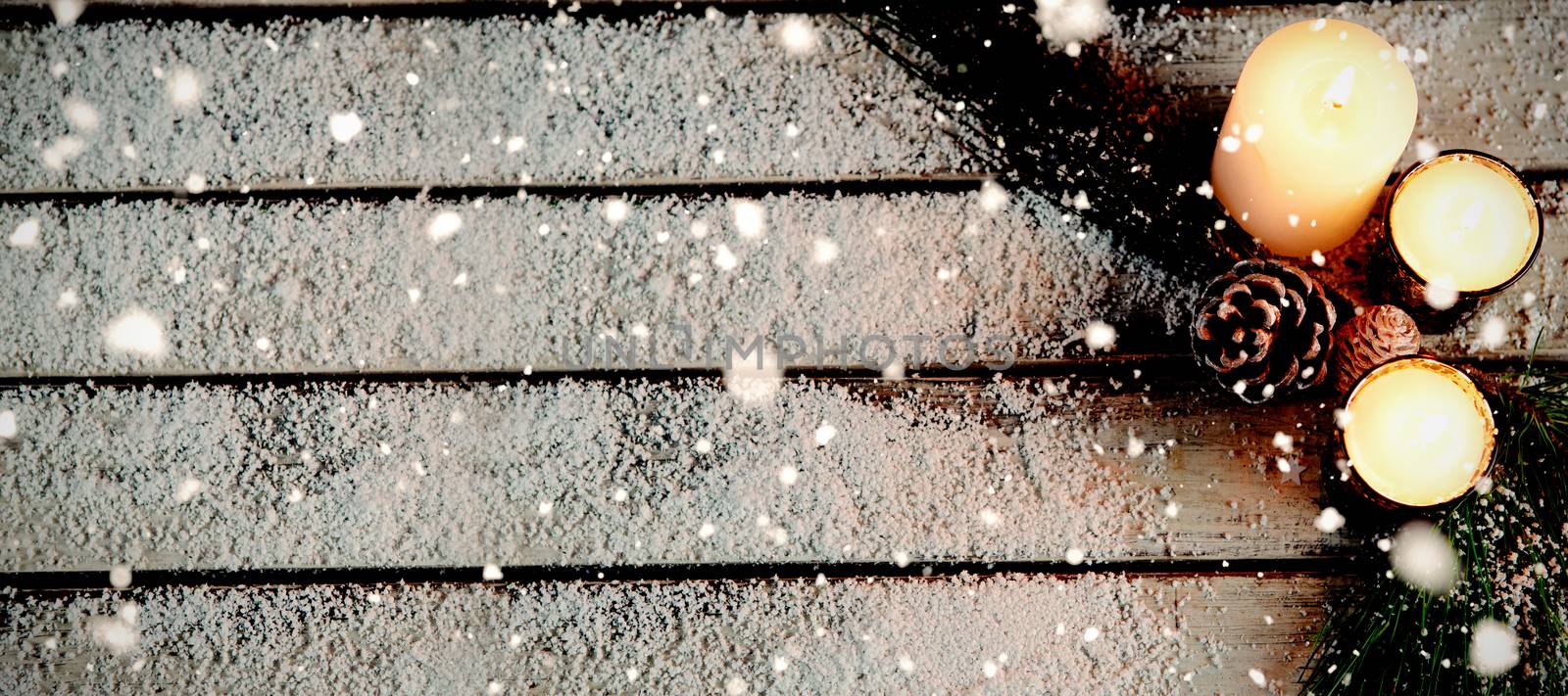 Snow falling against copy space in the snow with candles