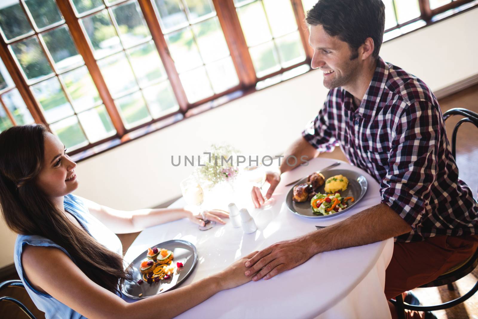 Romantic couple holding hands in restaurant