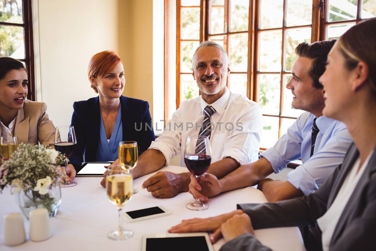 Business people talking with each other at the table by Wavebreakmedia