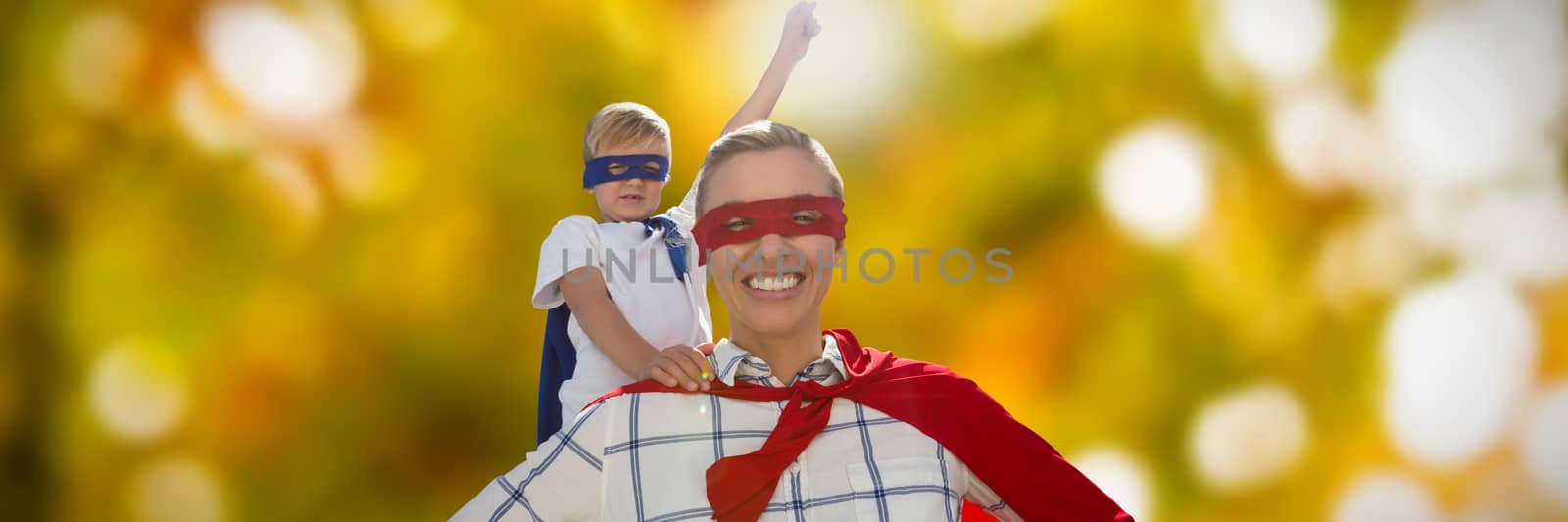 Mother and son pretending to be superhero against defocused image of tree