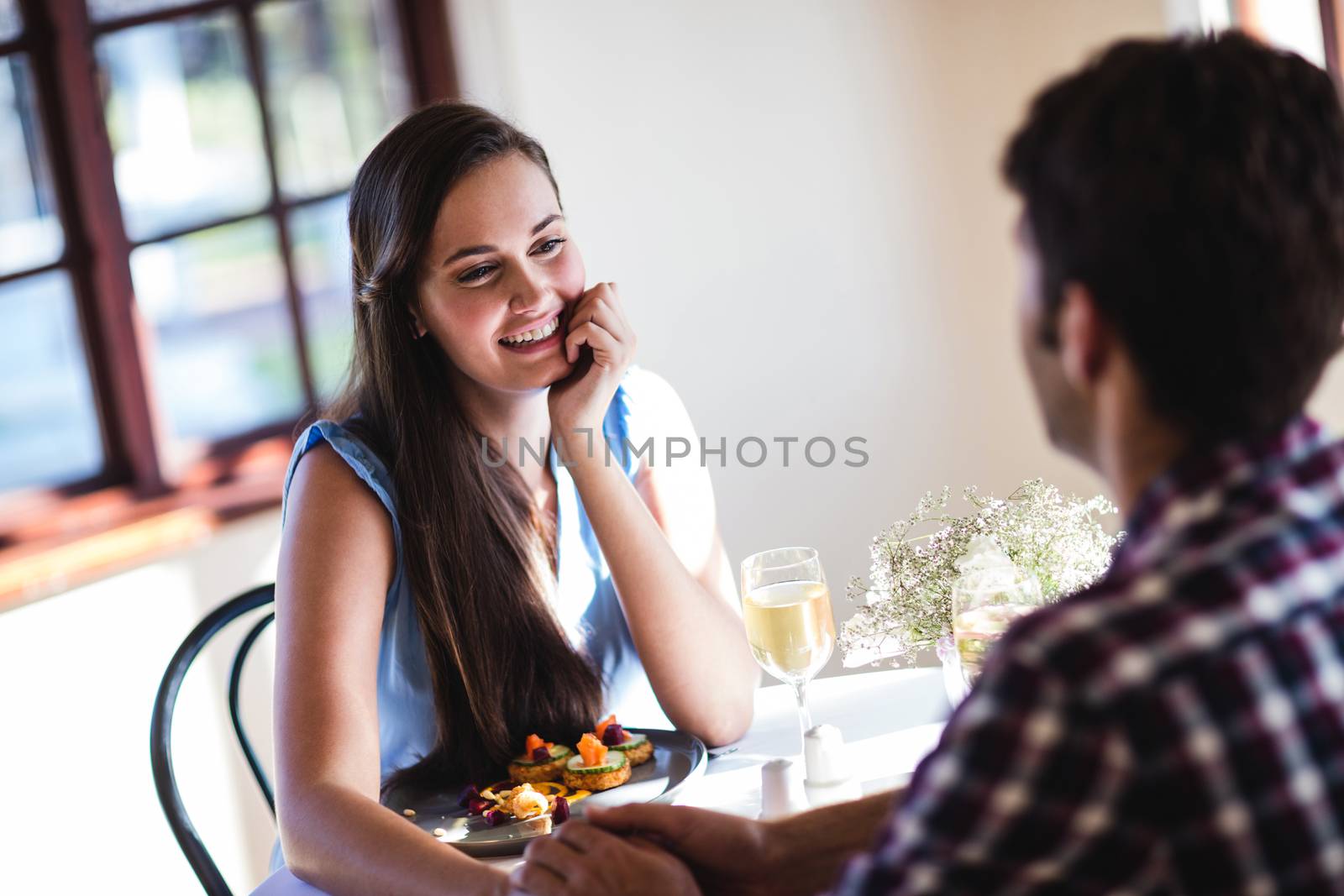 Couple holding hands in restaurant by Wavebreakmedia