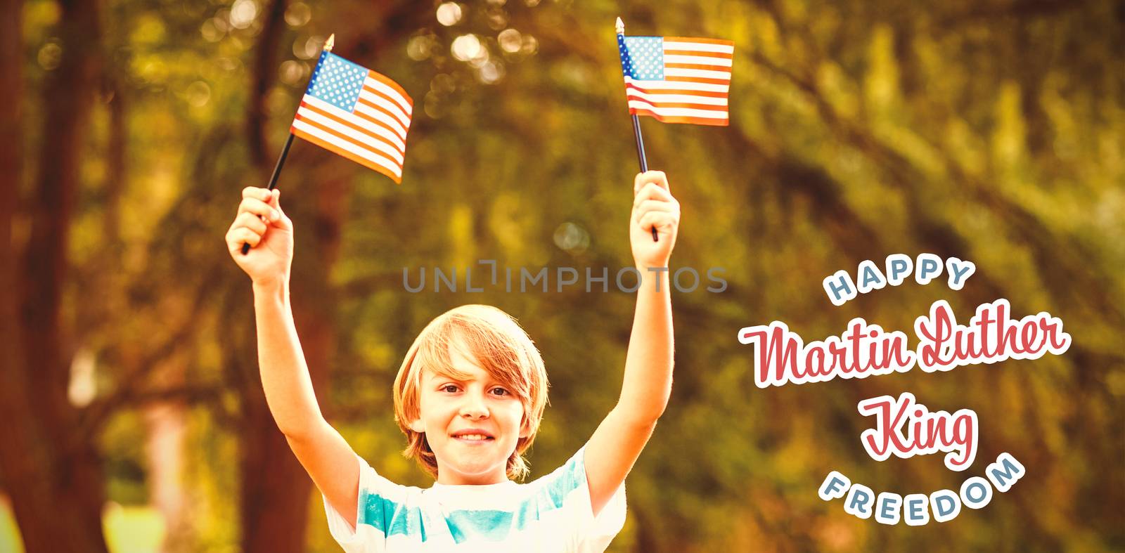 Portrait of boy showing American flags against happy martin luther king freedom