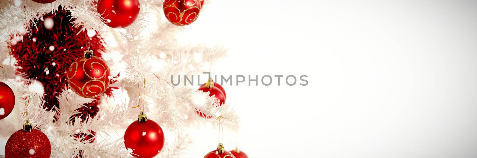 Snow falling against red and white christmas decorations
