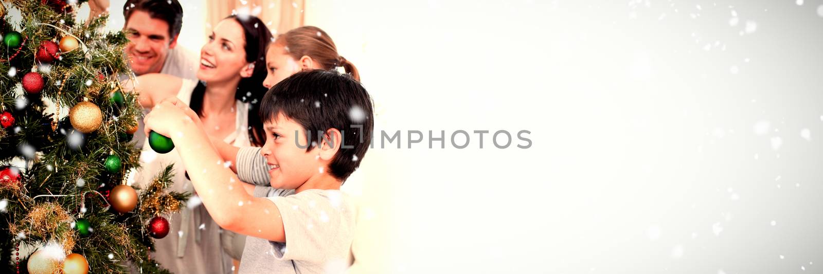 Composite image of happy family decorating a christmas tree with boubles by Wavebreakmedia