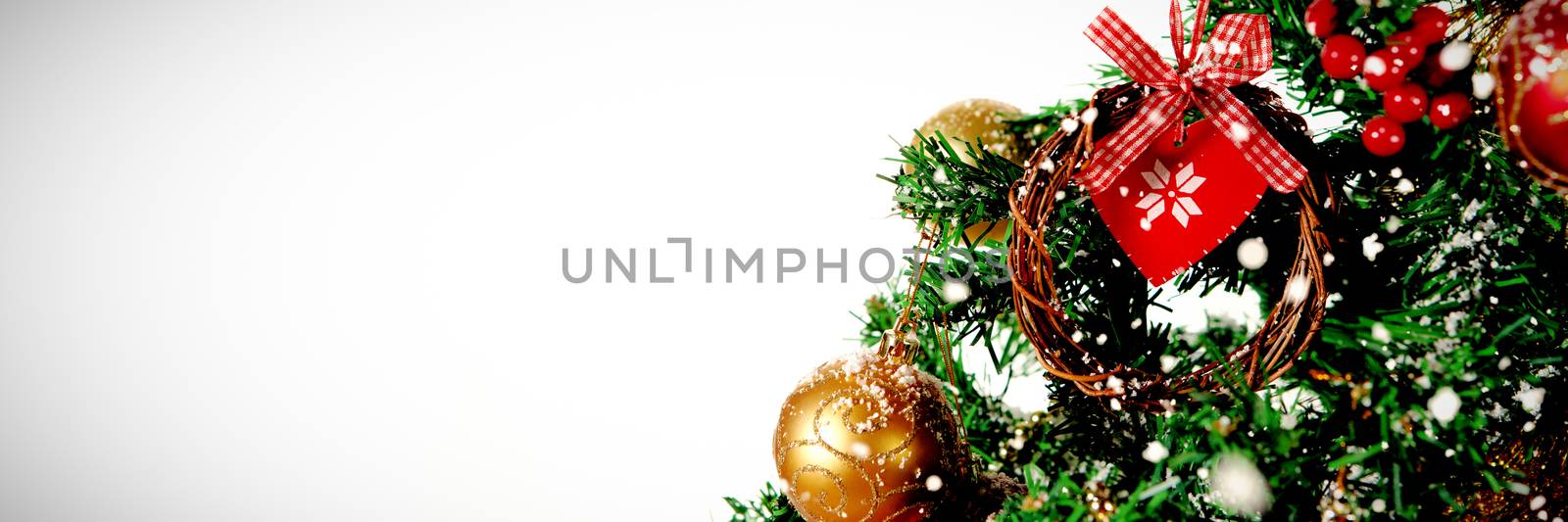 Snow falling against part of christmas tree against white background