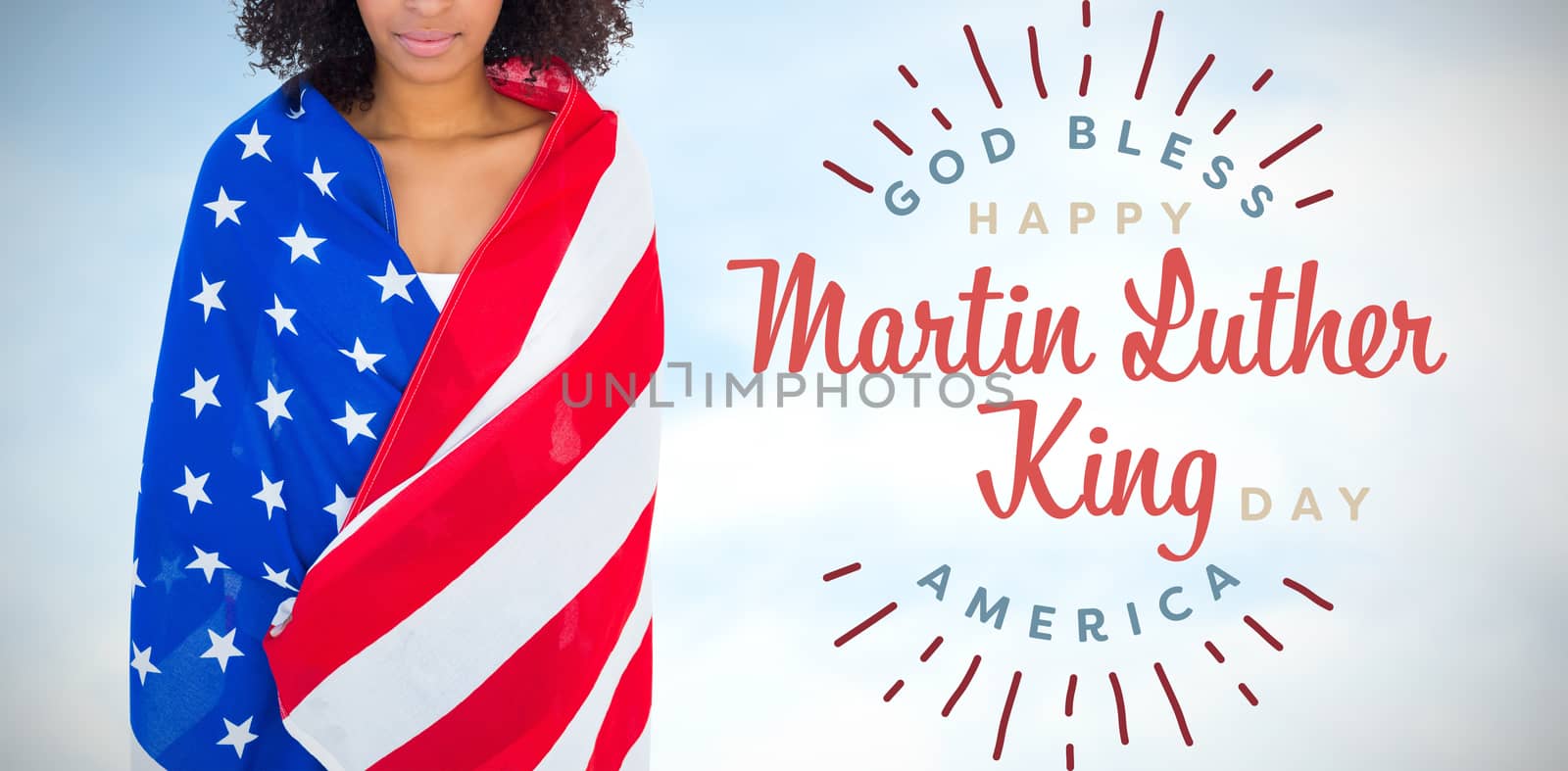 Pretty girl wrapped in american flag smiling at camera against blue sky with clouds 