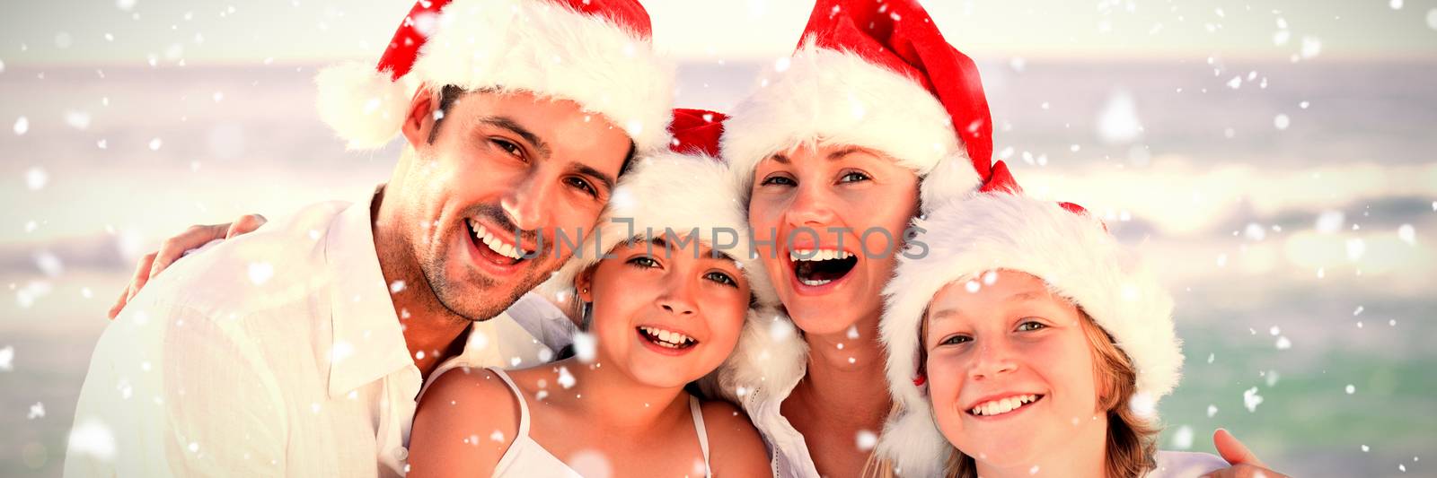 Composite image of family during christmas day at the beach by Wavebreakmedia
