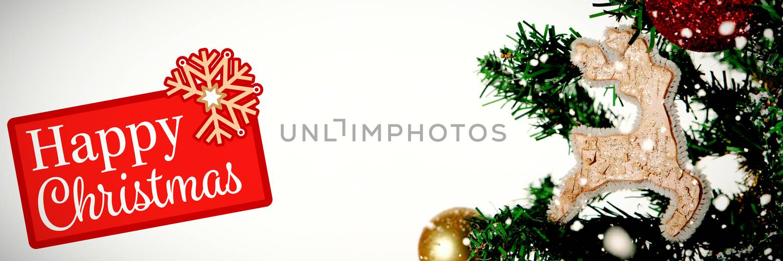 Greetings board against christmas ornaments hanging in tree with copy space