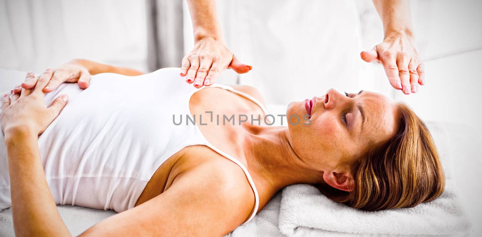 Woman receiving reiki treatment at spa