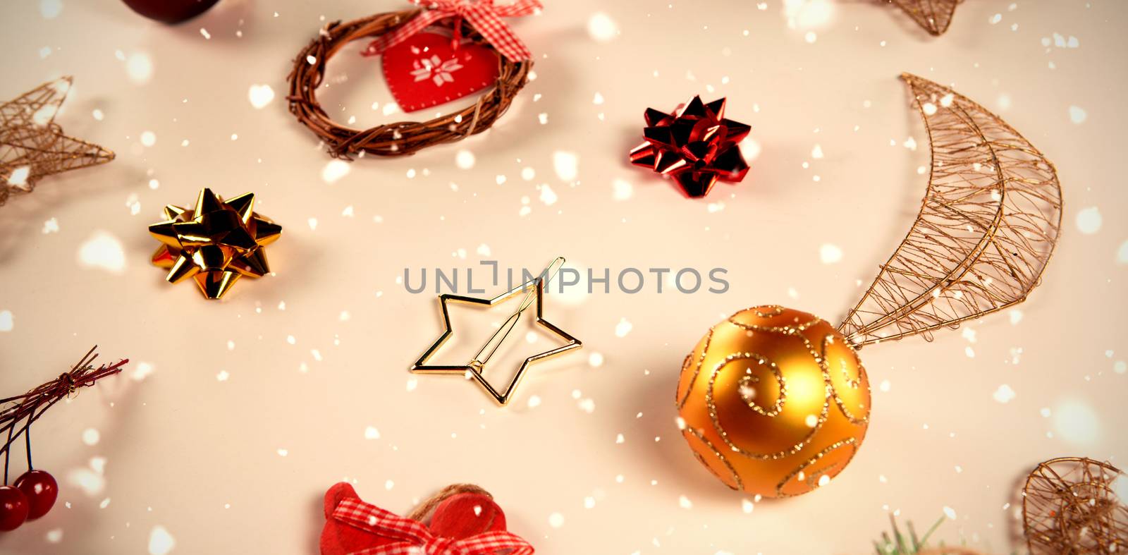 Snow falling against several christmas ornaments