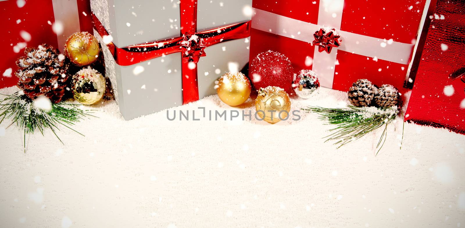 Snow falling against colorful christmas decorations in snow