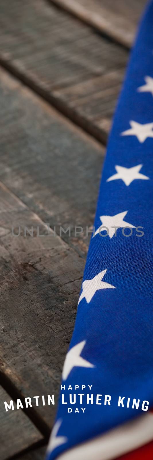 happy Martin Luther King day against folded american flag on wooden table