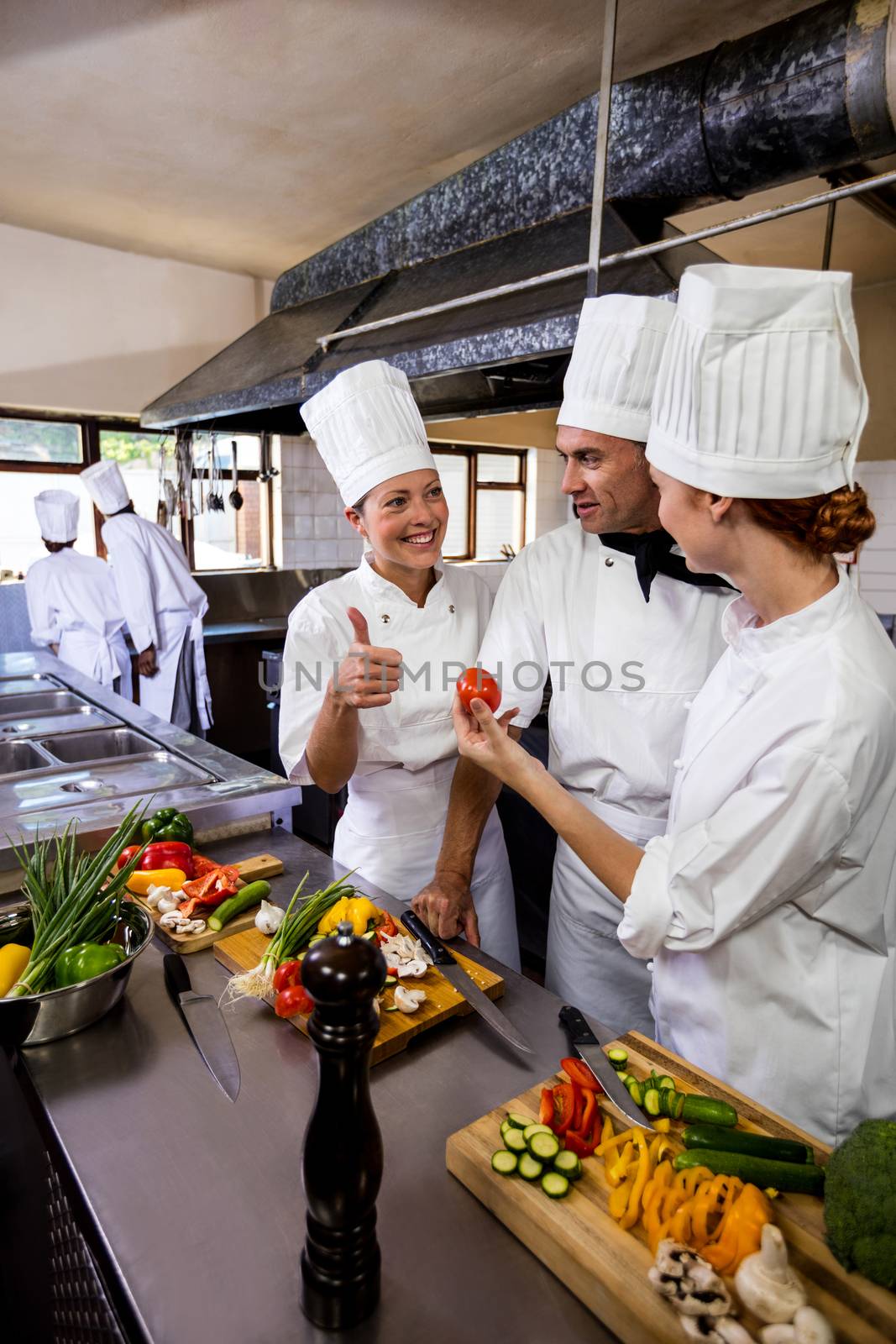 Group of chefs interacting with each other in kitchen at hotel