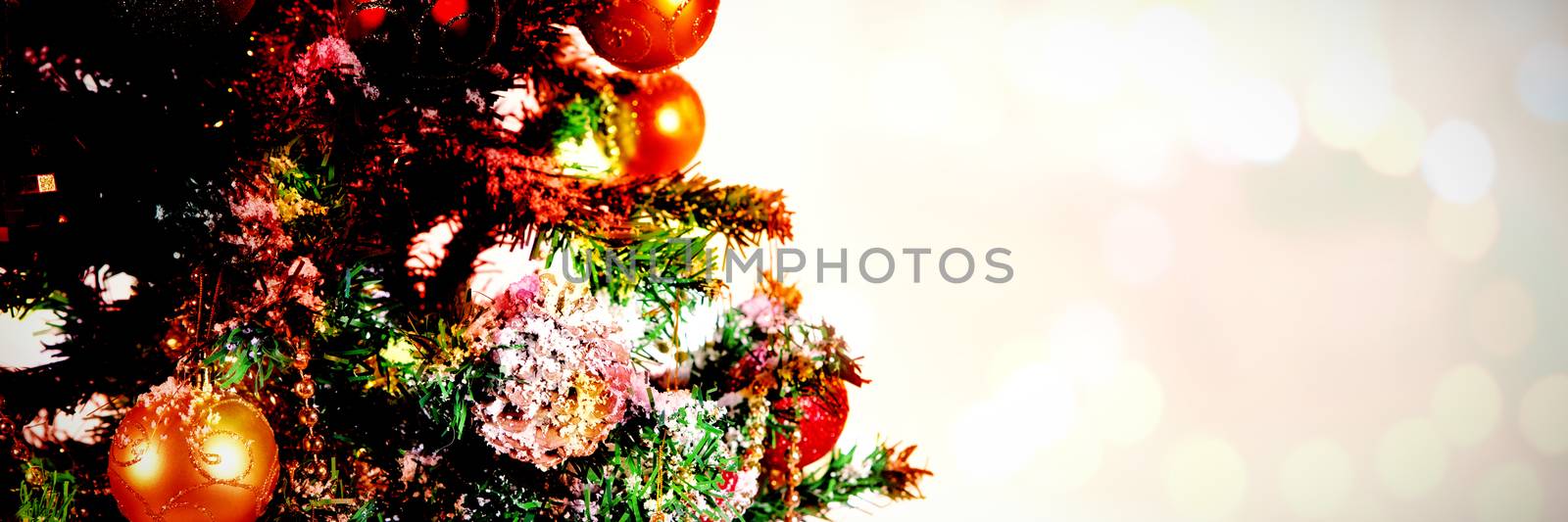 Composite image of table against christmas decorations hanging in tree